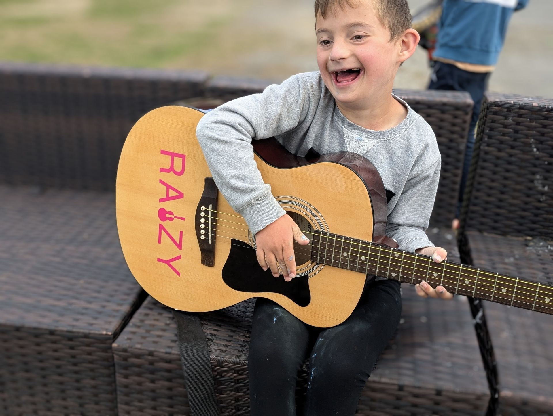 A young boy is holding a guitar.