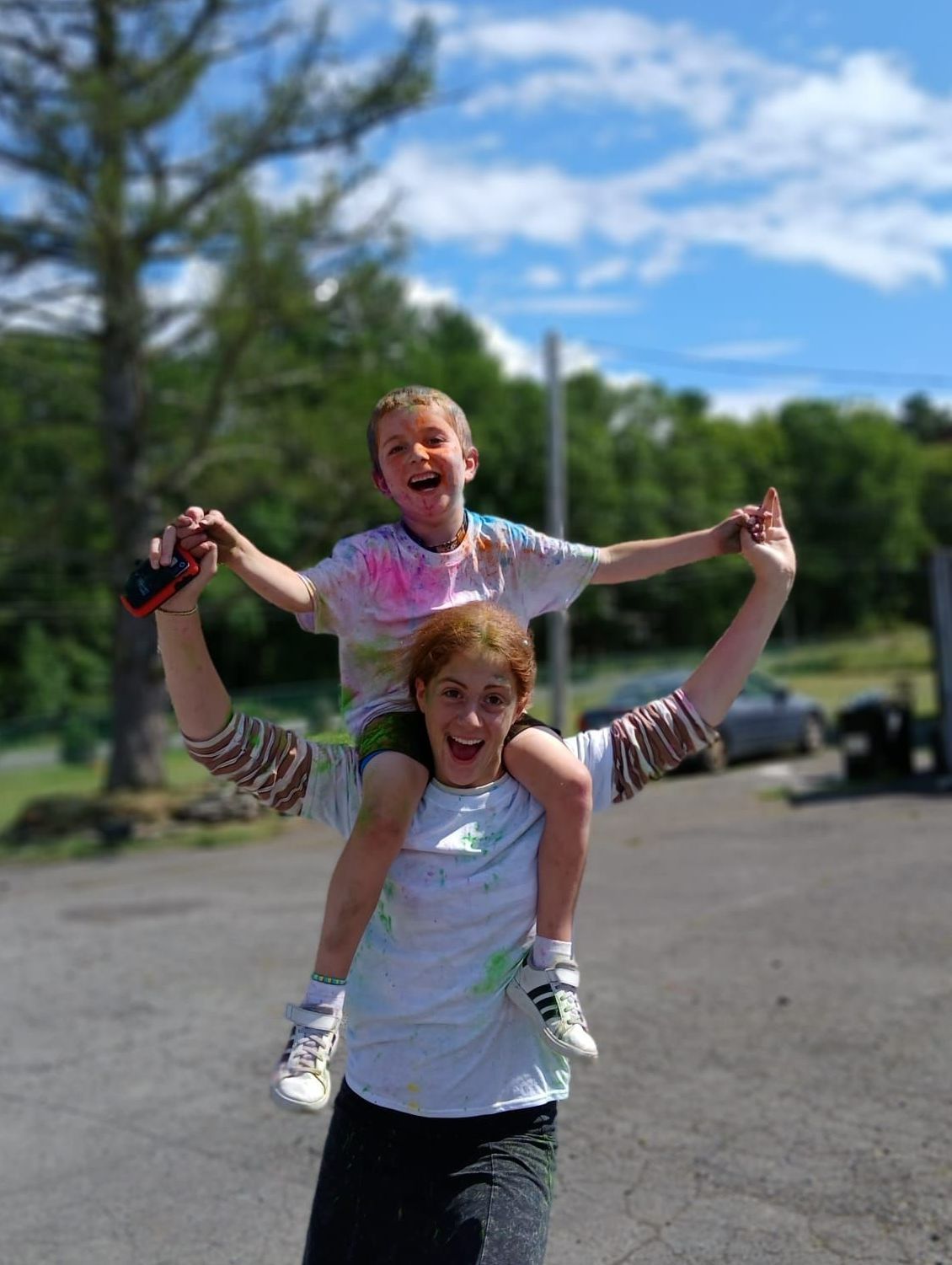 A woman is carrying a child on her shoulders.
