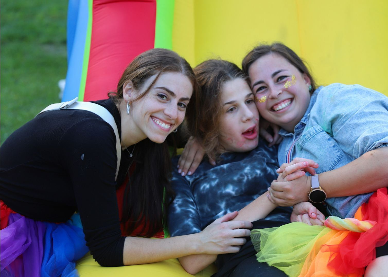 Three women are posing for a picture on a bouncy house.