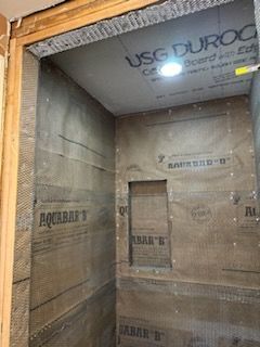 A bathroom is being remodeled and the walls are covered in plywood.