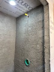 A shower stall is being built in a bathroom.