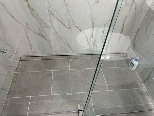 A bathroom with a walk in shower and a toilet.