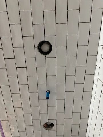 A ceiling with white tiles and two lights on it.