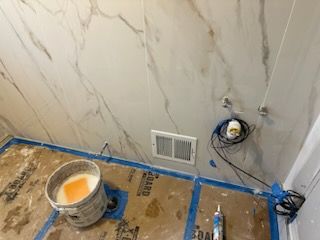 A bathroom under construction with a bucket of paint on the floor.