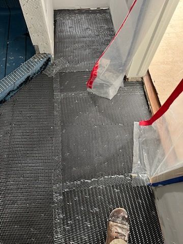 A person is standing in a room with a plastic bag on the floor.