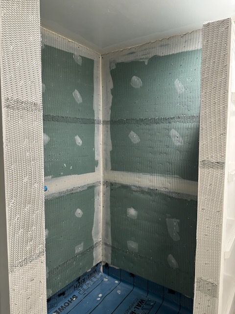 A room with a lot of drywall on the walls and a blue floor.