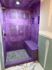 A shower is being built in a bathroom with purple walls.