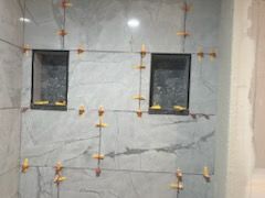 A bathroom is being remodeled and there are two niches in the wall.