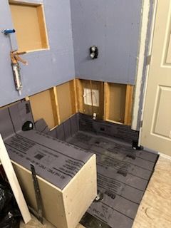 A bathroom is being remodeled with a bathtub being built into the wall.
