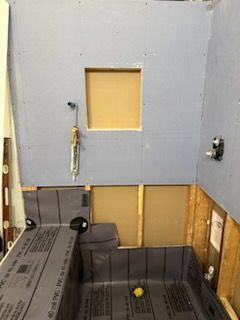 A bathroom is being remodeled and a shower is being installed.