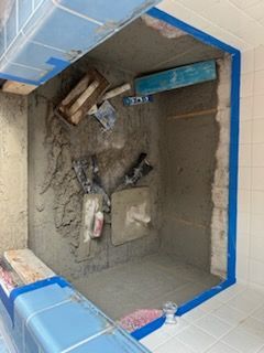 A room with a lot of concrete and tools on the floor.