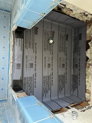 A bathroom with a hole in the wall that looks like a swimming pool.