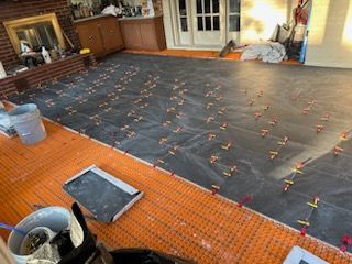 A living room with a lot of tiles on the floor and a fireplace.