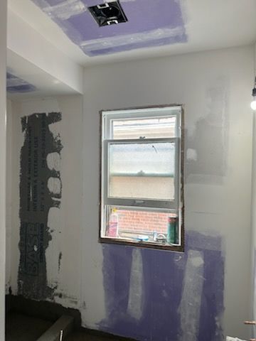 A room with a window and a ceiling that is being remodeled.