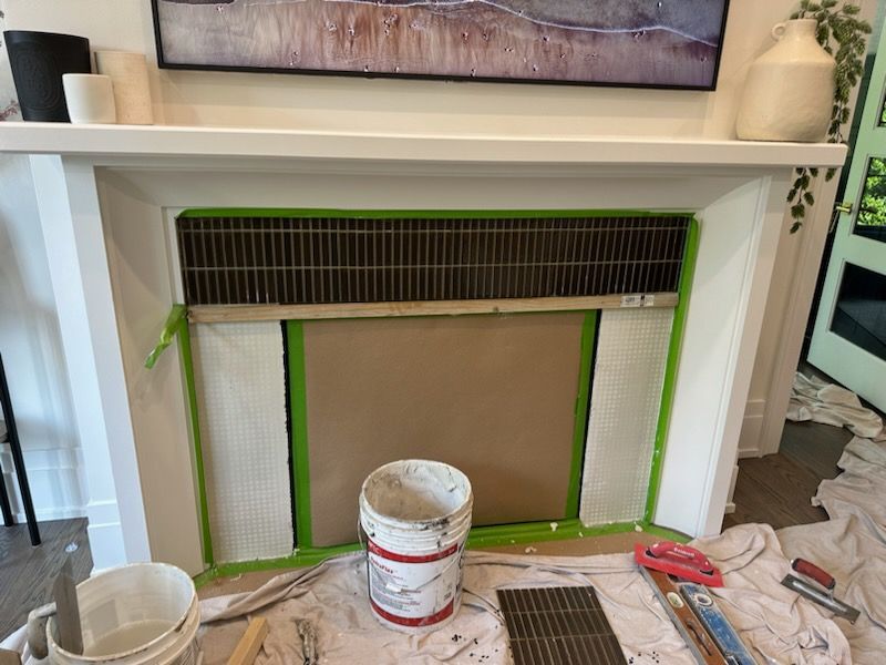 A fireplace is being painted in a living room.