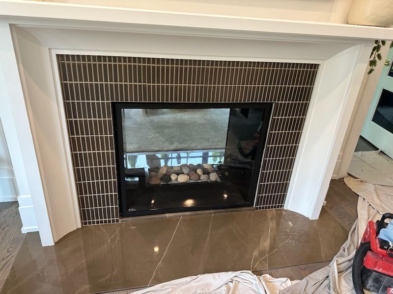 A fireplace with a vacuum cleaner in front of it