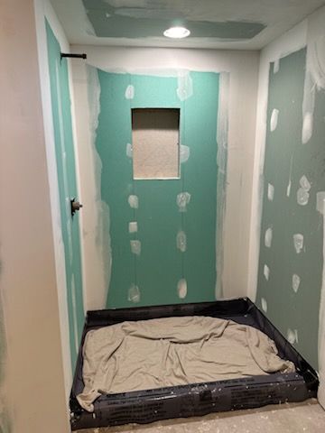 A bathroom is being remodeled and a shower stall is being built.