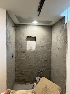 A bathroom under construction with a hole in the wall.