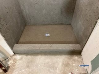 A concrete shower stall is being built in a bathroom.