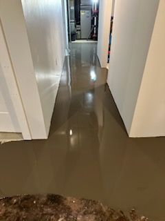 A hallway with a concrete floor in a house.