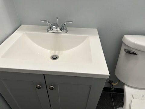 A bathroom sink with a toilet next to it.