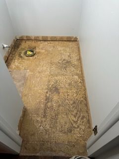 A bathroom with a marble floor and a toilet.