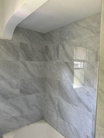 A bathroom with marble tiles and a toilet.