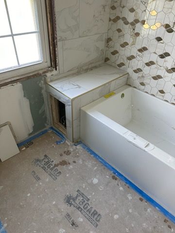 A bathroom under construction with a bathtub and a window.