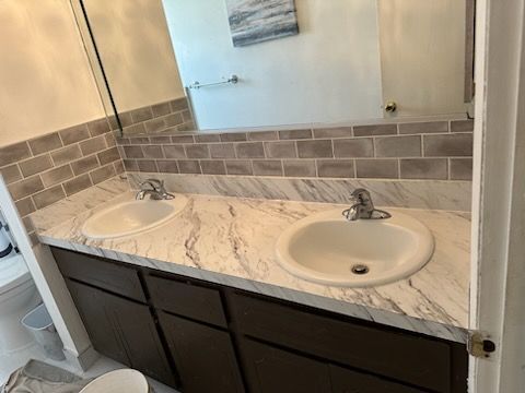 A bathroom with two sinks and a mirror.