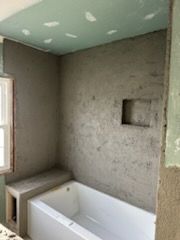 A bathroom with a bathtub and a window.