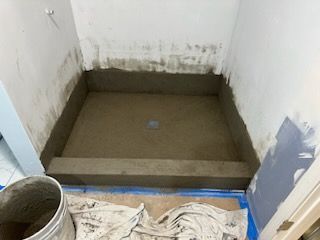 A shower stall is being built in a bathroom.