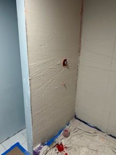 A bathroom is being remodeled and there is a hole in the wall.