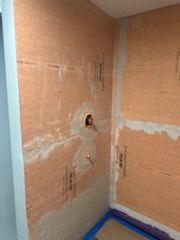 A bathroom is being remodeled and a shower is being installed.