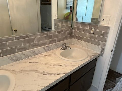 A bathroom with two sinks and a mirror.