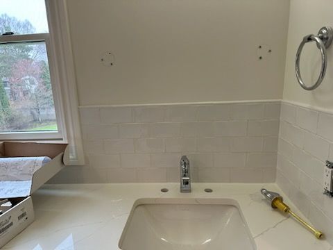 A bathroom with a sink and a window.