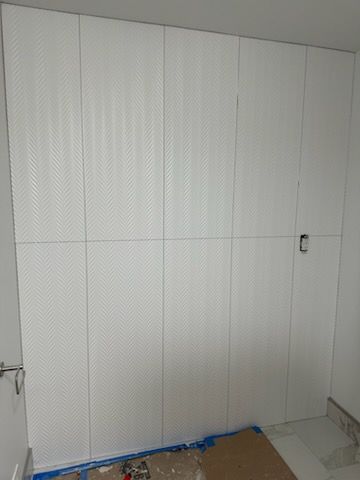 A room with a lot of white cabinets on the wall.