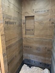 A bathroom with wooden walls and a tiled floor.
