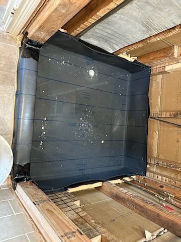 A black box is sitting on top of a wooden floor in a room.