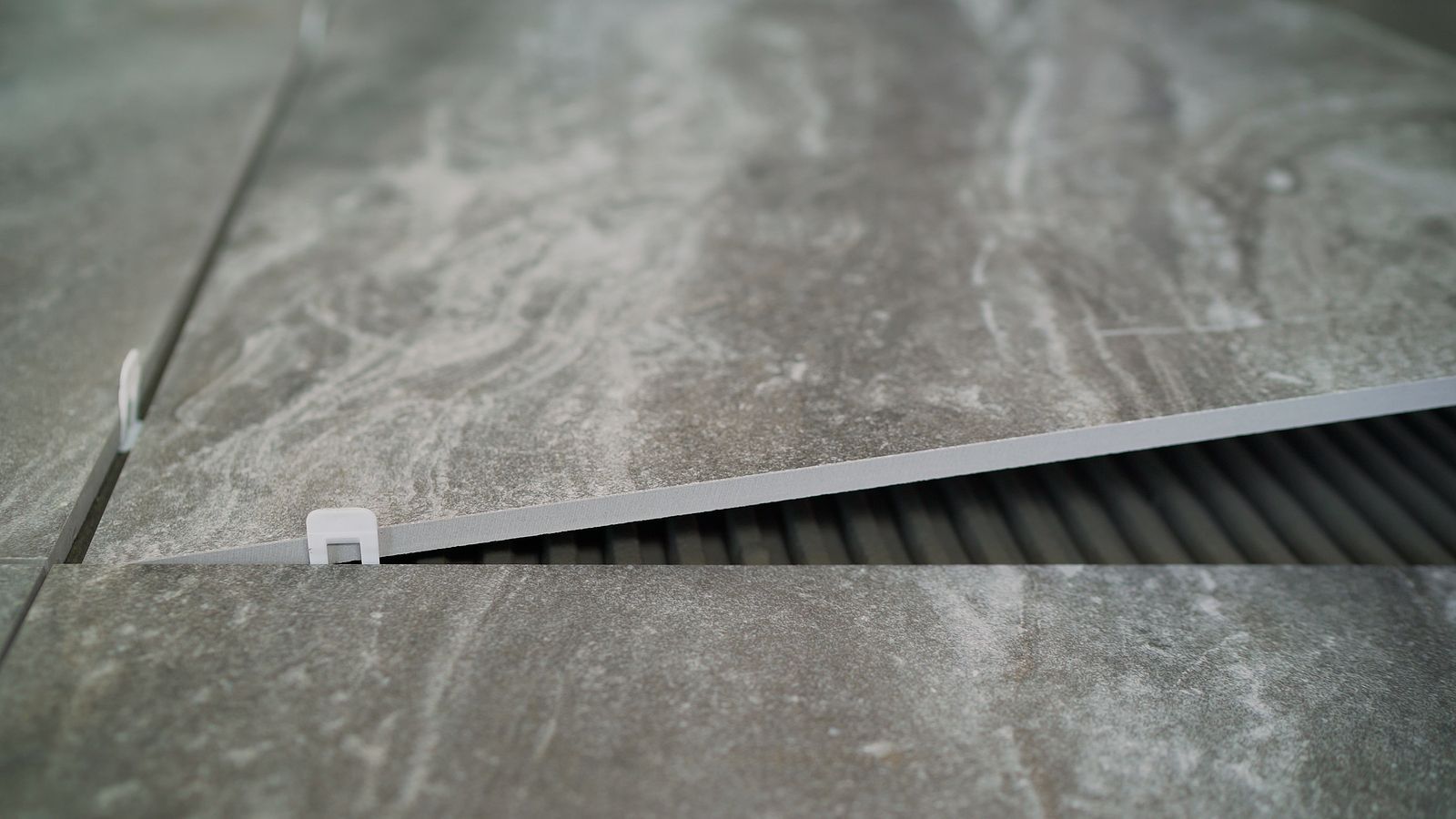 A close up of a tile being installed on a floor.