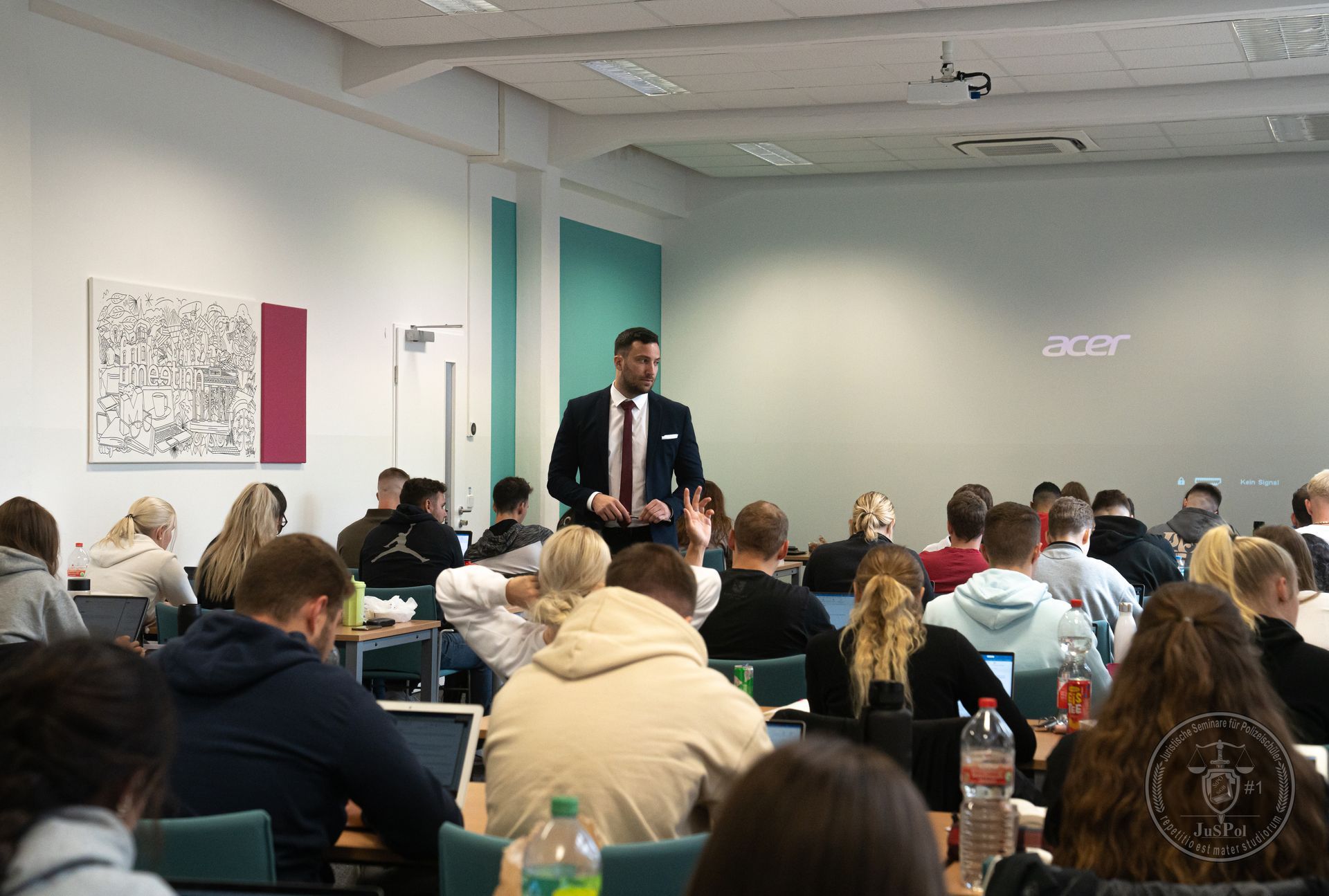 Foto aus eine Klassenzimmer, mit Damir Rodic mittig stehend.