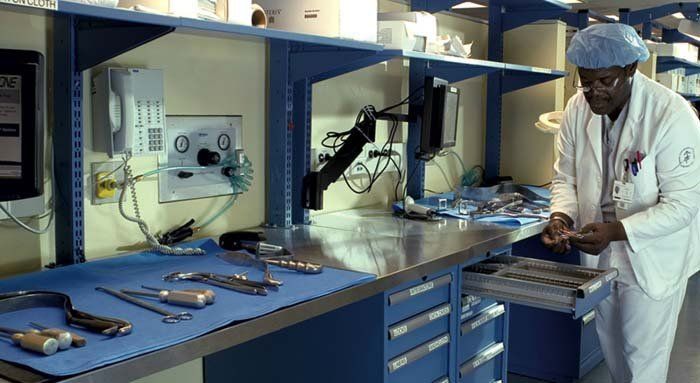 medico in laboratorio con scaffali e cassettiere