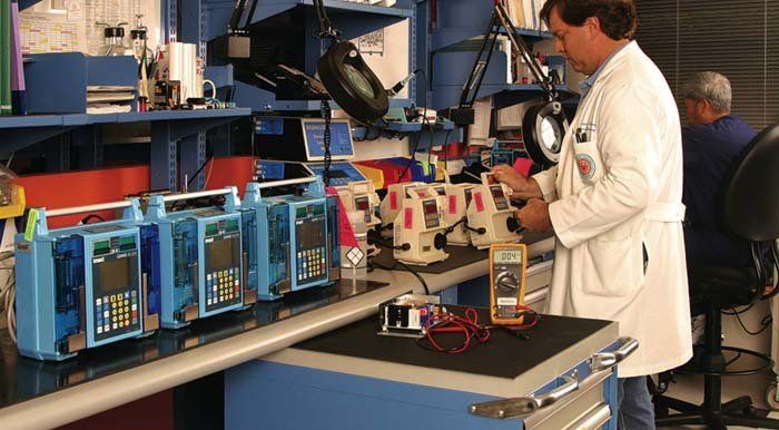 tecnico in laboratorio con cassettiera e scaffali metallici