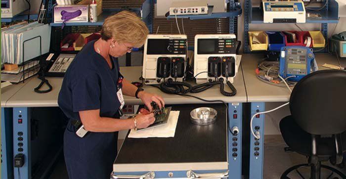 tecnico di laboratorio lavora su ripiano di cassettiera metallica