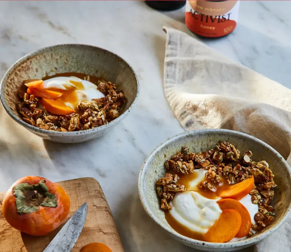 Two bowls of food on a table next to a bottle of chivas