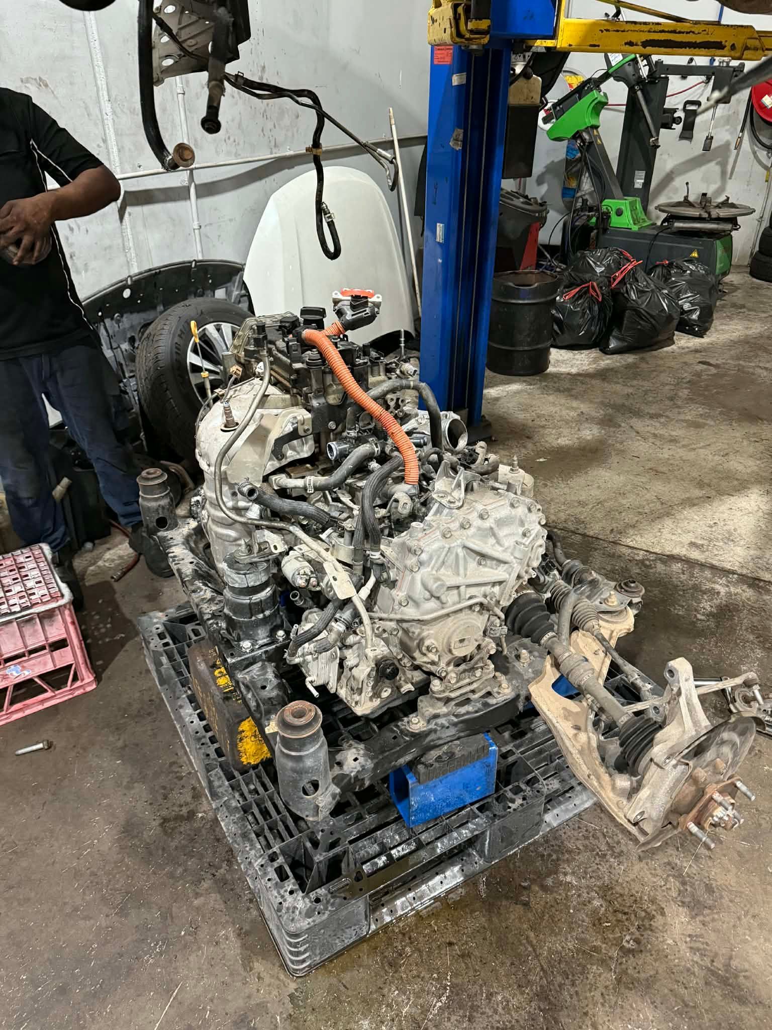 A Large Car Engine Sits On A Black Pallet Inside A Mechanical Garage — Elite Fleet Auto in Cannonvale, QLD