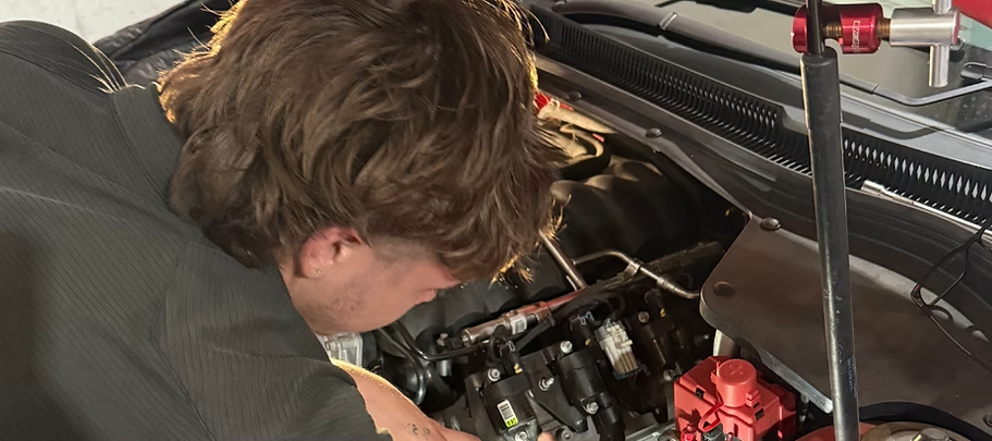 A Person Leans Over An Open Car Hood — Elite Fleet Auto in Cannonvale, QLD