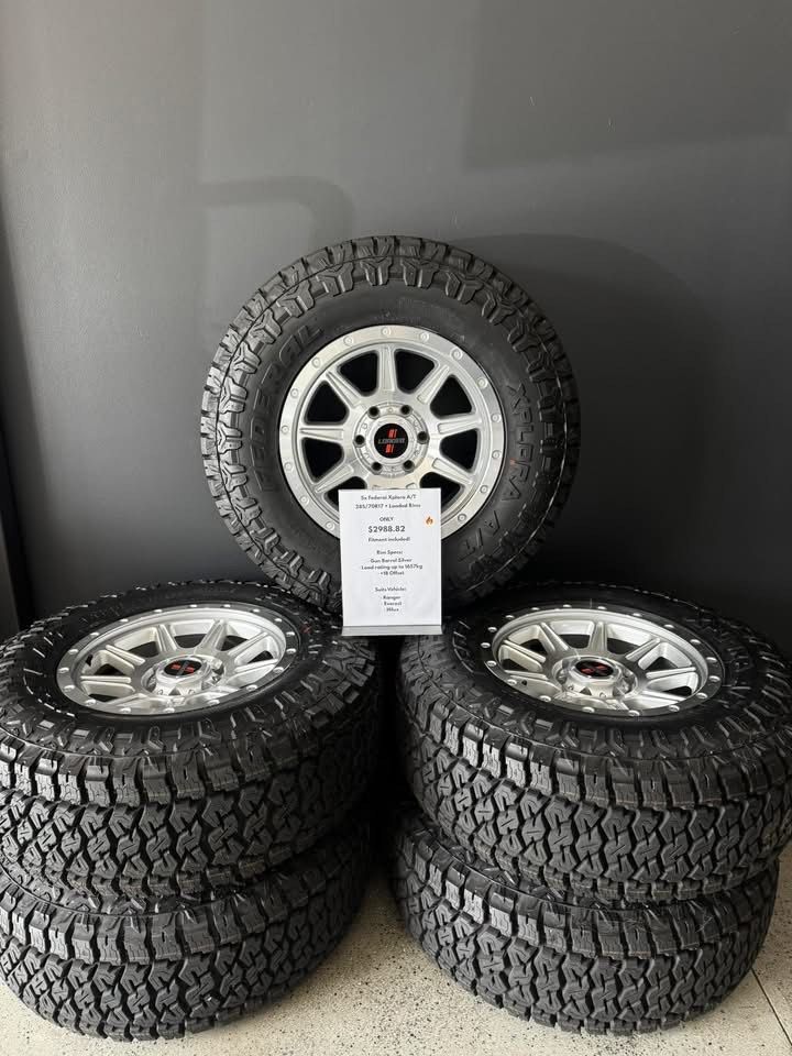 Four Off-road Tires With Silver Alloy Rims Stacked — Elite Fleet Auto in Cannonvale, QLD
