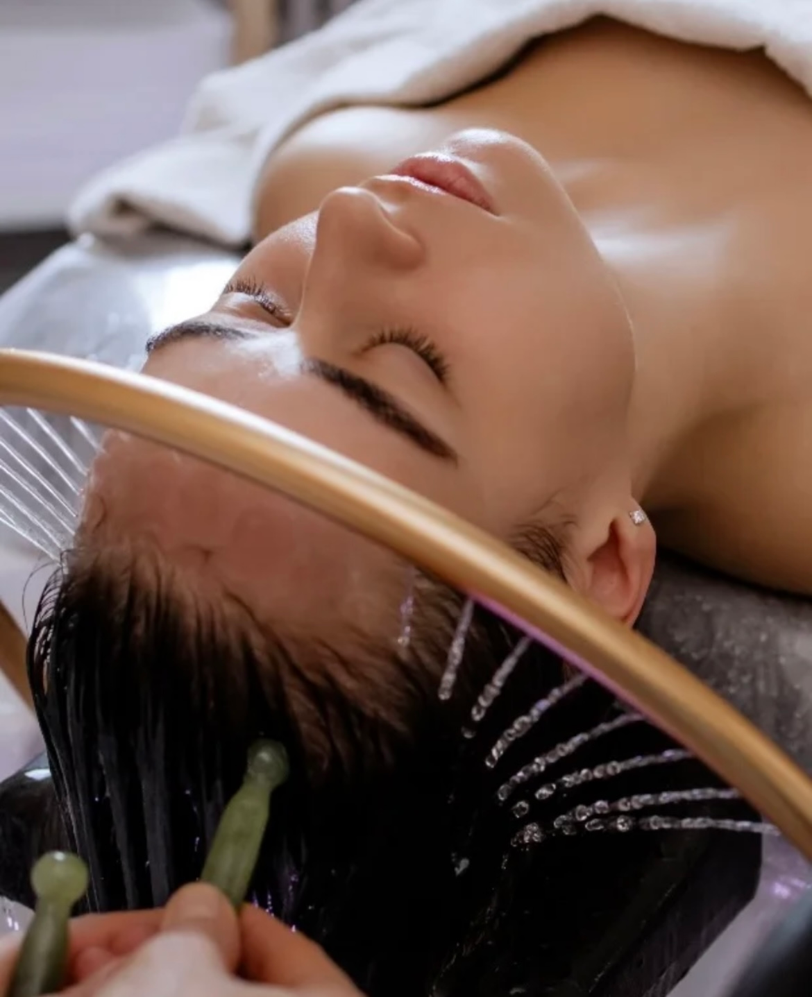 A woman is laying on a table with her eyes closed