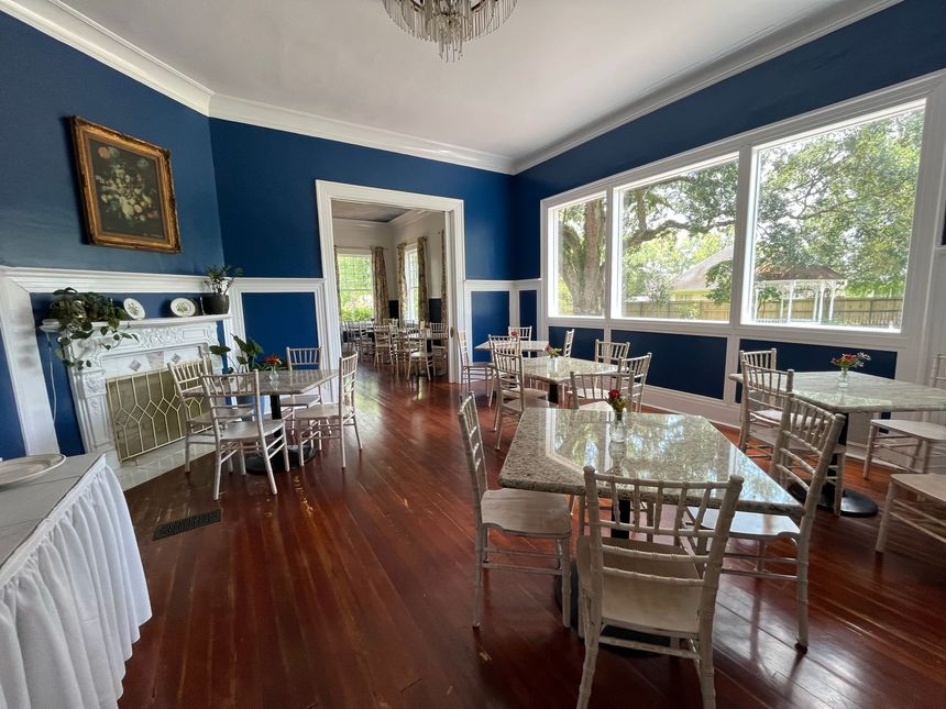 A screened in porch with a table and chairs overlooking the ocean