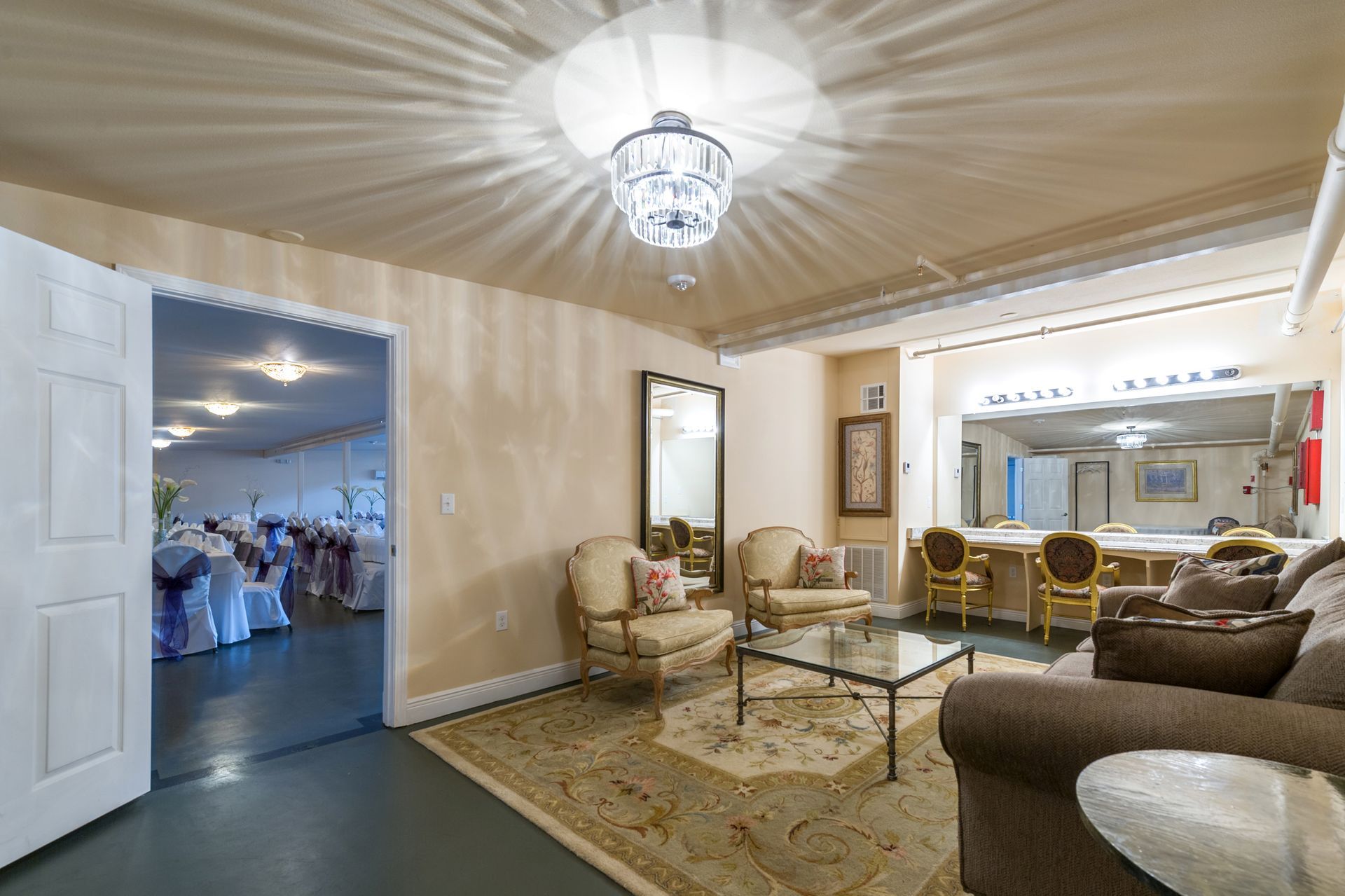 A living room with a couch , chairs , a coffee table and a mirror.